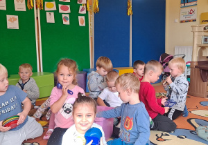 dzieci wspólnie bawią się na dywanie różnymi zabawkami